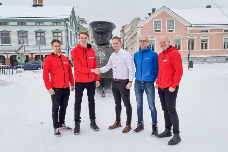 Sorcolorin toimitusjohtaja kättelee Laatutrio Maalaus Oy:n toimitusjohtajaa talvisessa Oulussa Toripolliisi-patsaan edessä.