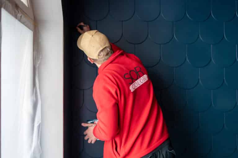 Mies maalaa sinistä seinää