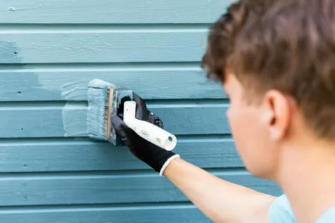 Maalari maalaa sinistä seinää